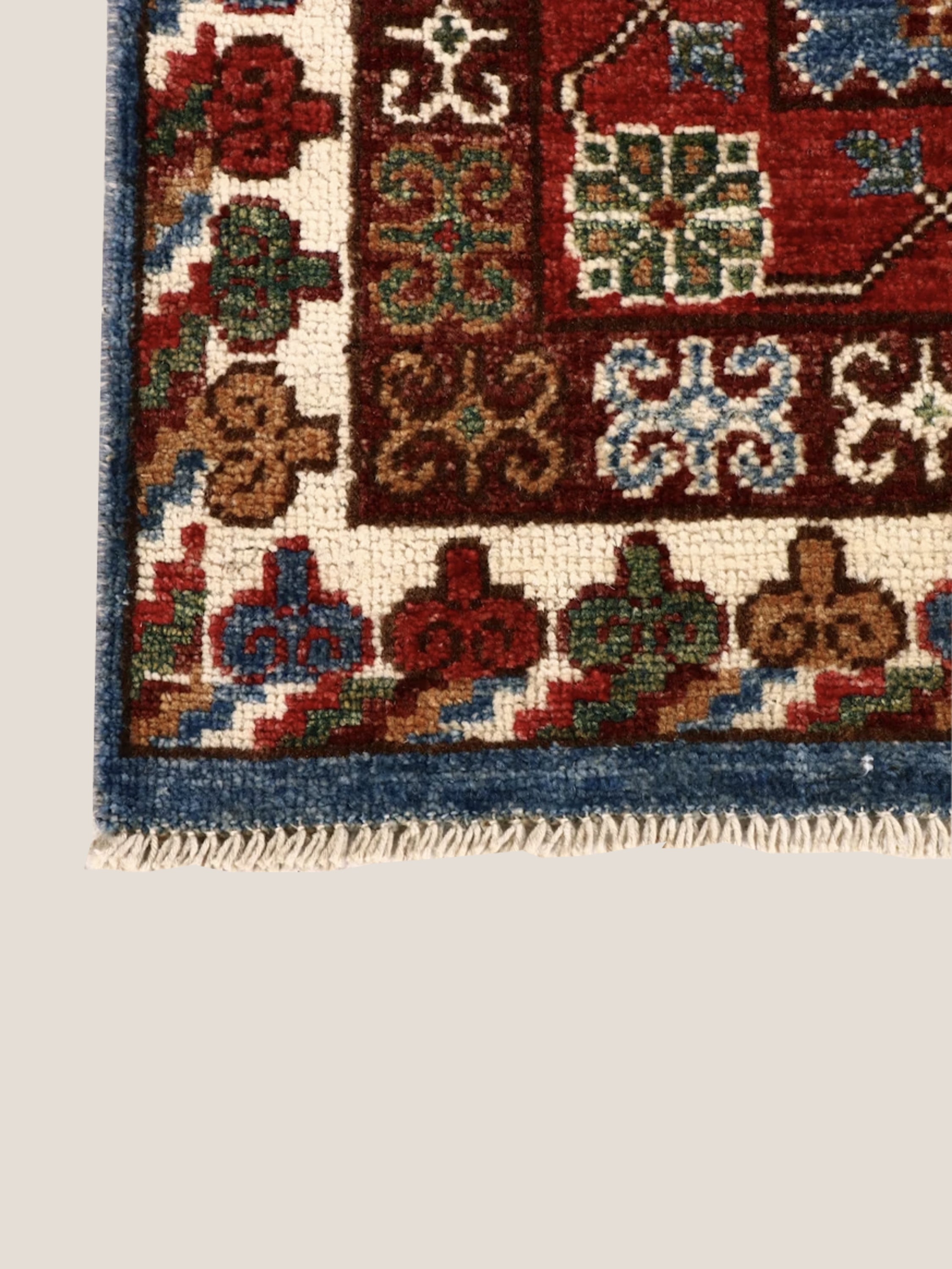 Handwoven vintage Afghan rug with intricate motifs and rich blue-red palette.