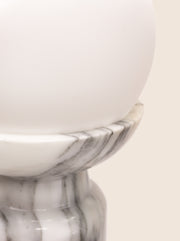 Folsom table lamp with sculptural marble base and glass or globe bulb.