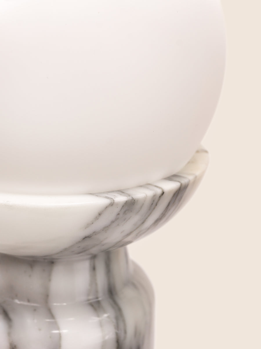 Folsom table lamp with sculptural marble base and glass or globe bulb.